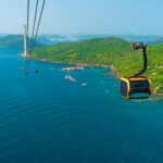 Aerial view of cable car gondola gliding over turquoise sea and green tropical island. Longest Hon Thom cable car ride in the world on Phu Quoc island, Vietnam. Modern tourism technology and infrastructure.
