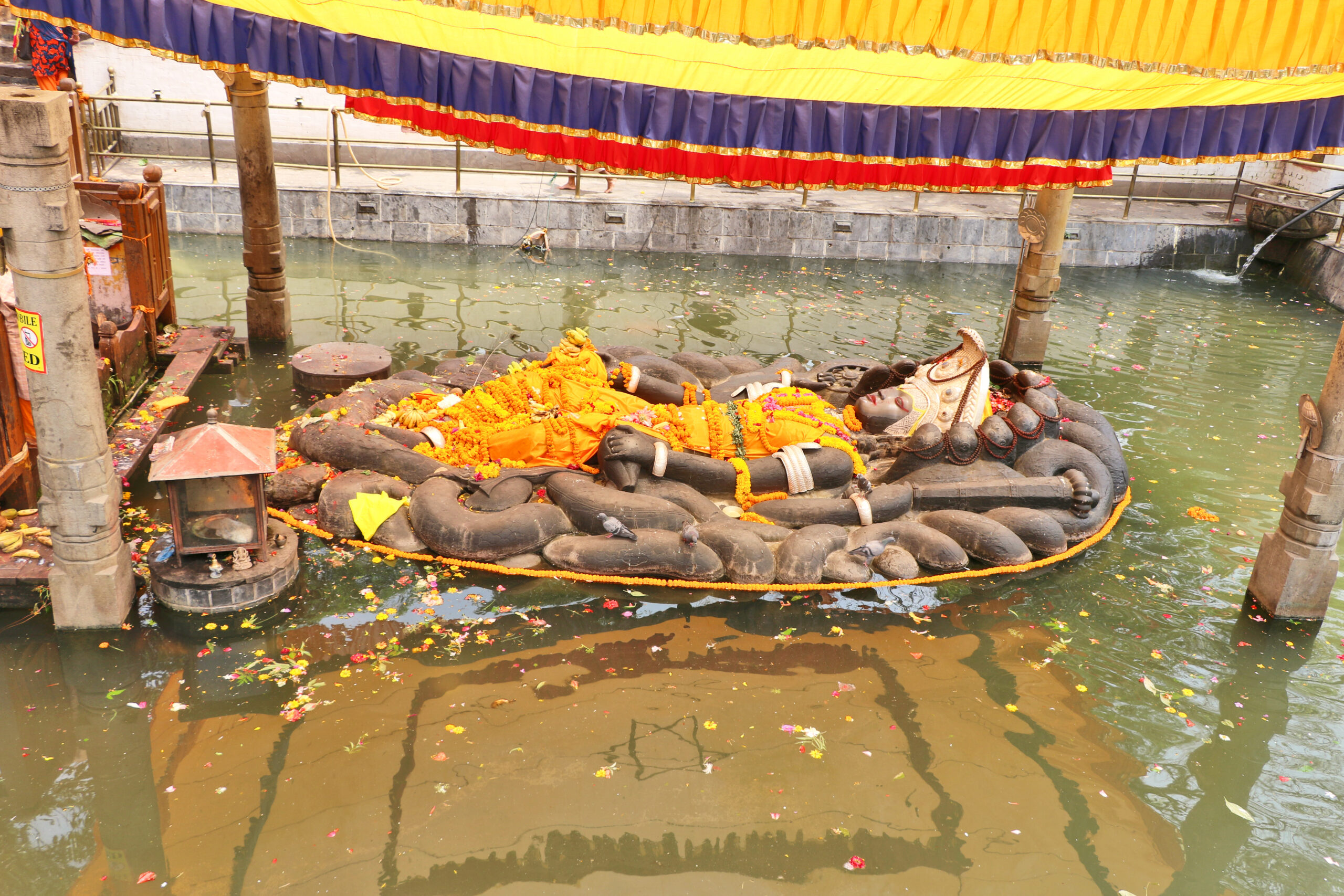 Budhanilkantha statue of the Hindu god Vishnu lies inside a recessed tank of water, Kathmandu, Nepal.