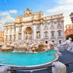 Trevi Fountain in Rome, Italy. Ancient fountain. Roman statues at piazza in old medieval city among traditional italian houses and street lamps. Famous landmark. Touristic destination for vacation.